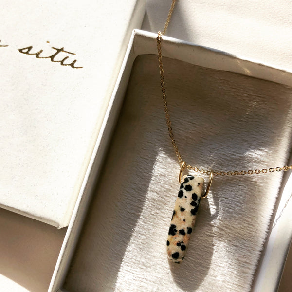 handmade, gold, dalmatian jasper stone necklace, placed in a white jewelry box 