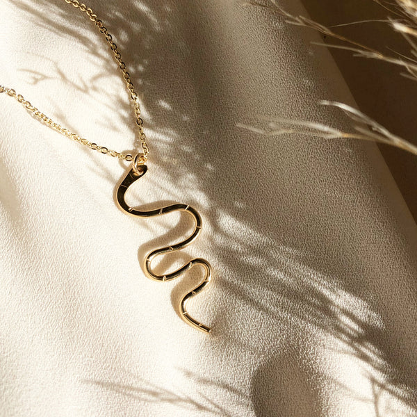 gold snake serpent necklace hangs from a gold filled chain 